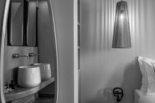 a bathroom with two sinks and a mirror at Kudos Suites Firostefani in Fira