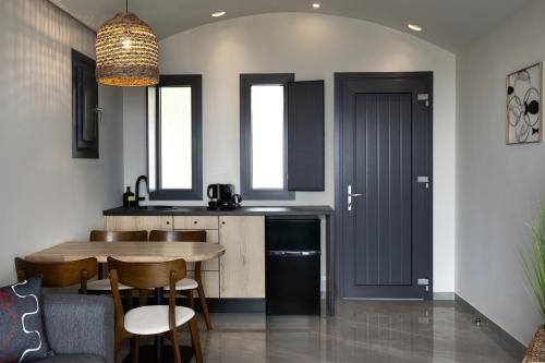 a kitchen with a table and chairs in a room at Kudos Suites Firostefani in Fira