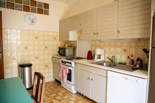 une cuisine avec un évier et une cuisinière four supérieur dans l'établissement Le Thiers - Near Sea House Garden 550m to Beach, à Saint-Cyprien