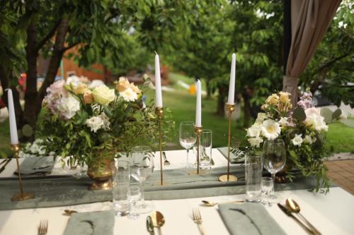a table with flowers and candles and glasses on it at Czereśniowe Wzgórze Sandomierz jakuzzi in Sandomierz