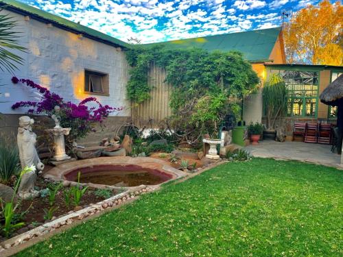 a garden with a pond in the yard at Namibgrens Guest Farm in Namibgrens