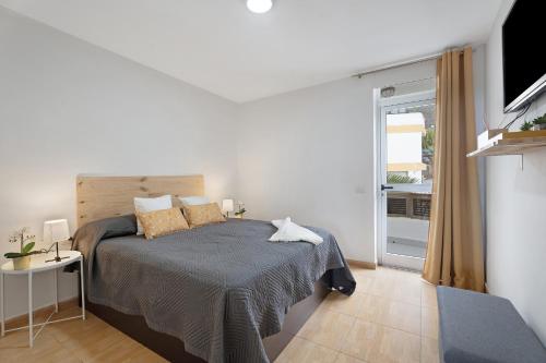 a bedroom with a bed and a sliding glass door at Vivir Bajamar in Bajamar