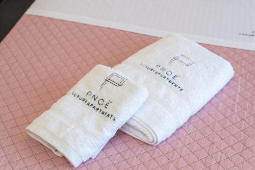 two towels are sitting on a pink table at PNOẼ Luxury Apartments in Lourdhata