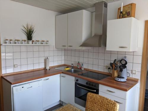 a kitchen with white cabinets and a sink at Ferienwohnung im Grünen I in Grebenstein