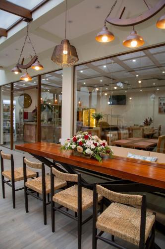 a long table in a restaurant with chairs and flowers at Dos Lunas Aparthotel in J. E. Estigarribia