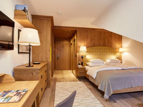 a bedroom with a large bed and a desk at Hotel Hochschober in Turracher Hohe