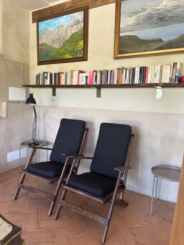 two chairs sitting next to a table with books at La Tana del Grifo - Podere Amodeo in Chiusi