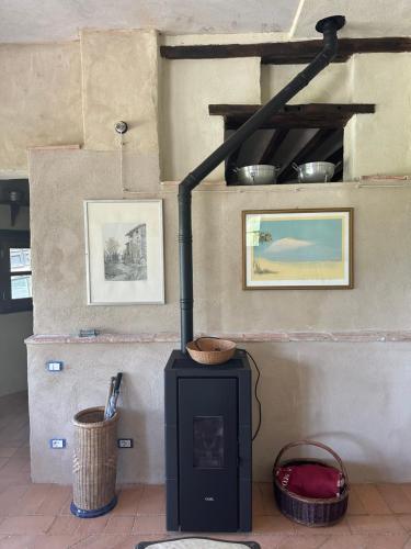a wood stove in a room with two pictures at La Tana del Grifo - Podere Amodeo in Chiusi