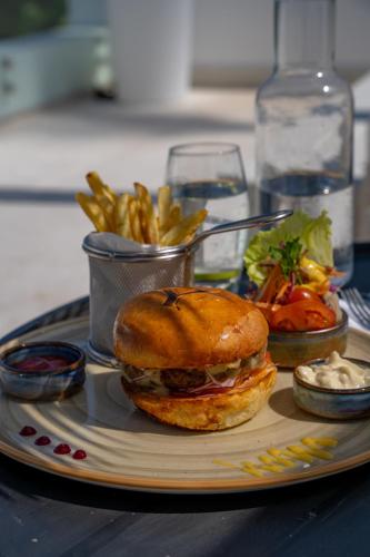 a plate of food with a sandwich and french fries at Ycona Eco-Luxury Resort, Zanzibar in Dikoni