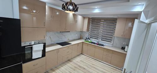 a kitchen with wooden cabinets and a black refrigerator at Green house 2 in Pogradec