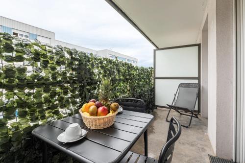 une corbeille de fruits sur une table sur un balcon dans l'établissement Le Cœur d'Annemasse - Appt 6p à 20 mn du Lac Léman, à Ville-la-Grand