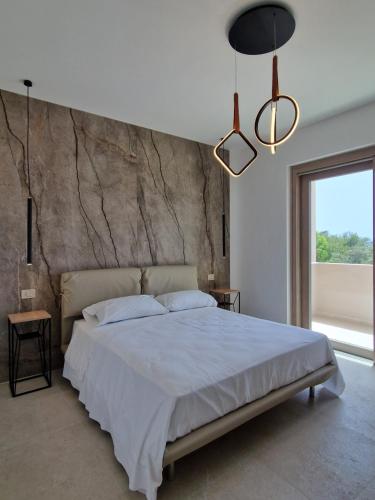 a bedroom with a large bed and a large window at Il Crepuscolo Marispica in Santa Maria Del Focallo