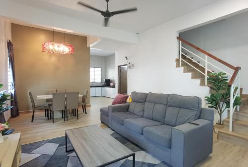 a living room with a couch and a table at Cosy 2-Storey Holiday Home Vines 2 @Pasar Malam -1 in Brinchang