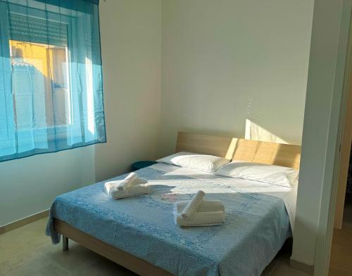 a bedroom with a bed with two towels on it at VILLA BELVEDERE Seaview Apartments - Relax a due passi dal mare in Anzio
