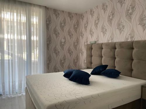 een slaapkamer met een bed met blauwe kussens erop bij Сарафово Лукс Тераса Първа Линия in Sarafovo