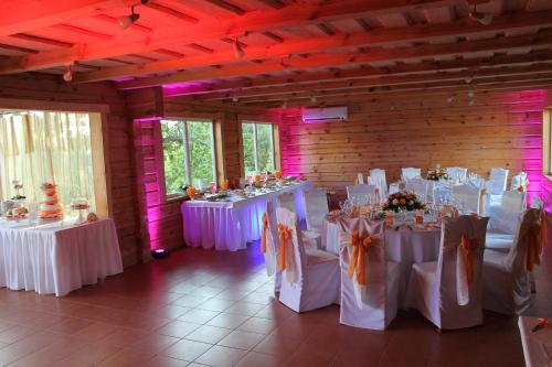 a room filled with tables with white tablecloths at Svajonių Dvaras in Balninkai