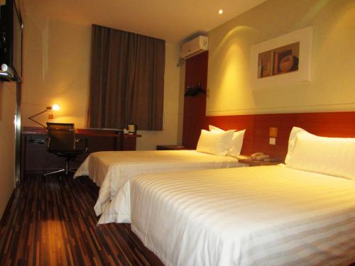 Un pat sau paturi într-o cameră la Goldmet Inn Changzhi Bayi Square
