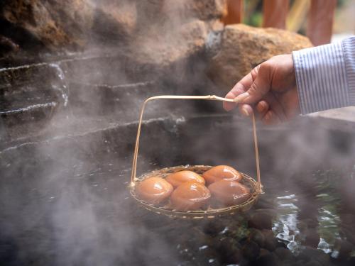 a person holding a basket of food on a grill at YU-FURI Nasu-Shiobara in Nasushiobara