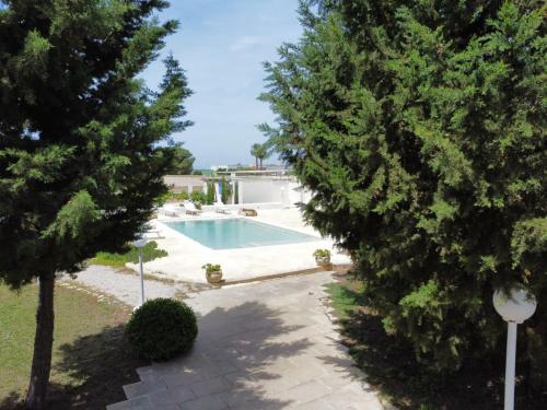 a swimming pool in a yard with trees at Villa Dei Lidi - HomeSalento com in Torre San Giovanni Ugento