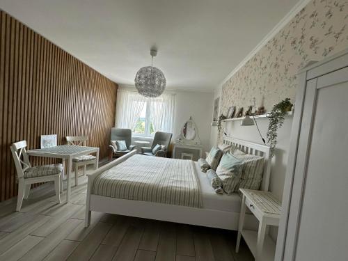 a bedroom with a bed and a table and chairs at Rudice romantický apartmán in Nezdenice