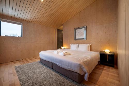 Un dormitorio con una cama grande y una ventana. en Foxwood F, en Niseko