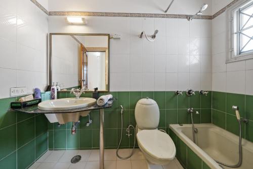 a bathroom with a sink and a toilet and a tub at Artist Abode in Bangalore