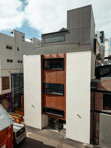 un edificio con una porta arancione sul lato di The Cobbler Hotel a Wellington