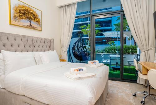 une chambre avec un lit et un bureau et un balcon dans l'établissement Zapbed House - AZIZI RIVIERA, à Dubaï
