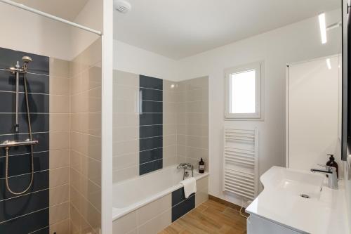 une salle de bain avec une baignoire blanche et un lavabo dans l'établissement La Marin'home - Belle Maison 6p proche de la plage, à Pléneuf-Val-André