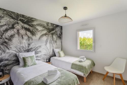 deux lits dans une chambre avec une fresque de palmiers dans l'établissement La Marin'home - Belle Maison 6p proche de la plage, à Pléneuf-Val-André
