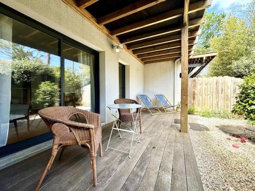 un patio avec des chaises et une table sur une terrasse dans l'établissement Appartement intimiste proche de la mer, à Arcachon