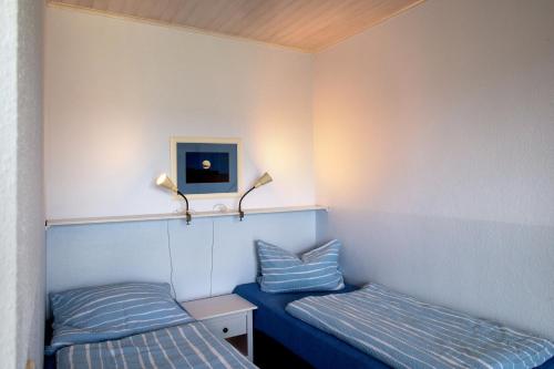 2 camas en una habitación pequeña con rayas azules en Möve Aba Appartment 44, en Rerik