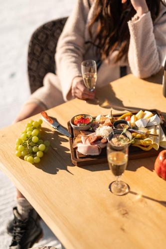 a woman sitting at a table with wine glasses and food at ADEA Lifestyle Suites Fieberbrunn in Fieberbrunn