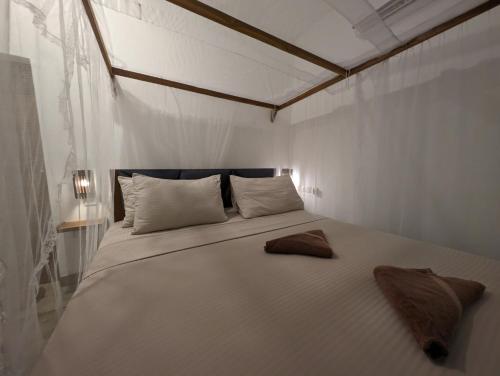 a bedroom with a large white bed with two pillows at Beach View in Arugam Bay
