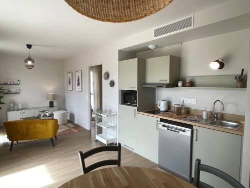 une cuisine et un salon avec une table et des chaises dans l'établissement Résidence MONTANA Bourg-en-Bresse, à Bourg-en-Bresse
