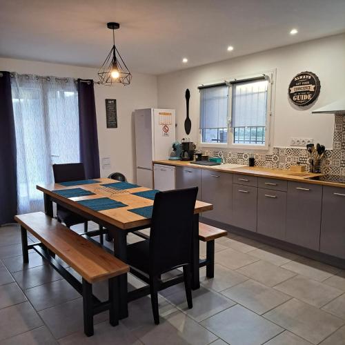 une cuisine avec une table, des chaises et un réfrigérateur dans l'établissement Maison confortable à Saint-Pierre-de-Clairac avec piscine privée, à Saint-Pierre-de-Clairac