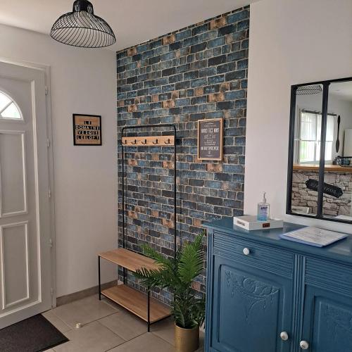 Cette chambre dispose d'une commode bleue et d'un mur en briques. dans l'établissement Maison confortable à Saint-Pierre-de-Clairac avec piscine privée, à Saint-Pierre-de-Clairac