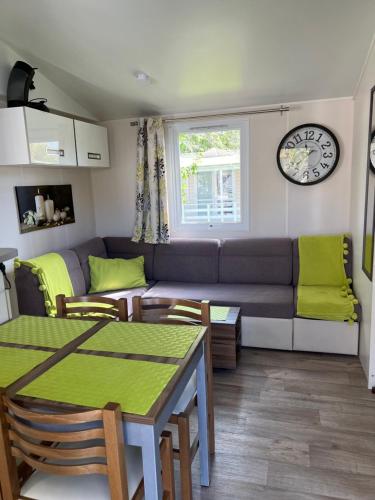 un salon avec un canapé et une table dans l'établissement Mobil-home de charme avec deux terrasses, à Vias