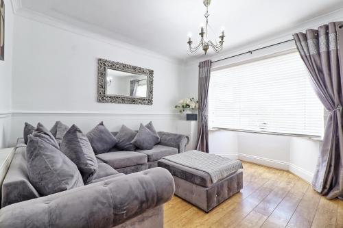 a living room with a couch and a window at LMV Property - Modern Luxury Family Home in Theydon Bois With London Skyline Views in Theydon Bois