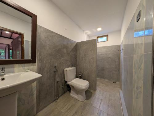 a bathroom with a toilet and a sink and a mirror at Beach View in Arugam Bay