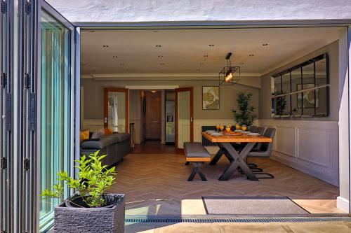 a dining room and living room with a table at LMV Property - Modern Luxury Family Home in Theydon Bois With London Skyline Views in Theydon Bois