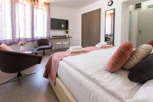a bedroom with a bed and a chair and a television at Csillag Villa in Balatonalmádi