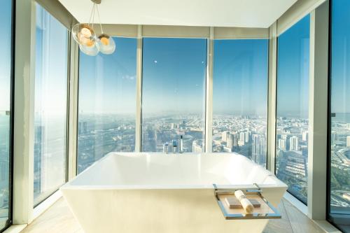 a bath tub in a bathroom with large windows at FIVE Jumeirah Village in Dubai