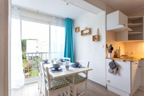 une cuisine avec une table et des chaises ainsi qu'une fenêtre dans l'établissement Chez Laurence - Élégant appartement climatisé avec wifi et parking, à La Grande Motte