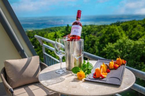 a table with a bottle of wine and a plate of food at Lifestyle Hotel Mátra in Mátraháza