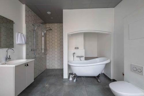 a bathroom with a tub and a sink and a toilet at Charming apartment in latin quarter of Copenhagen in Copenhagen