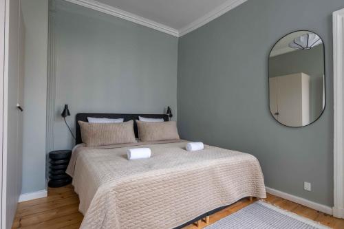 a bedroom with a bed with a large mirror at Charming apartment in latin quarter of Copenhagen in Copenhagen