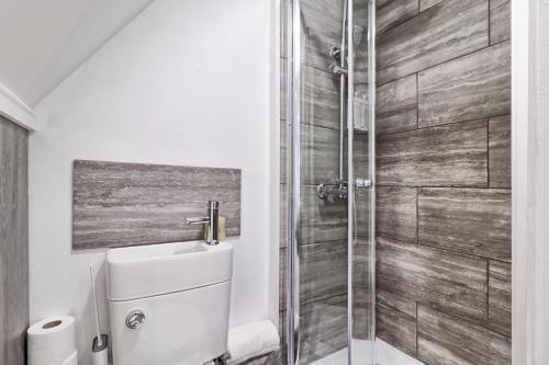 a bathroom with a shower with a sink and a toilet at LMV Property - Modern Luxury Family Home in Theydon Bois With London Skyline Views in Theydon Bois