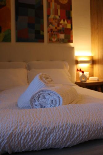 ein weißes Bett mit einem Handtuch darüber in der Unterkunft Hotel Morgana in Mendrisio