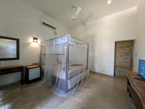 a room with a bed with a net in it at Beach View in Arugam Bay